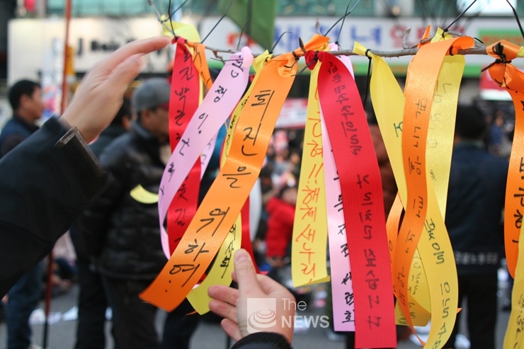 박근혜 대통령 퇴진과 김진태 의원 사퇴를 소원하는 리본을 달고 있는 시민들  <사진 노부호 기자>