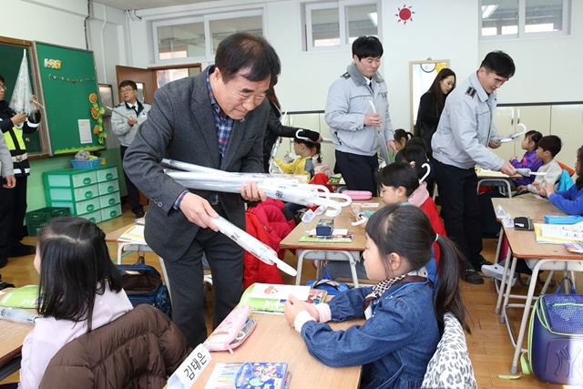 교통사고 예방홍보물인 어린이용 우산을 나눠주고 있는 이현종 철원군수 <사진 철원군>