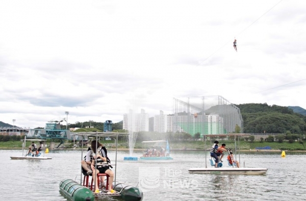일엽편주와 카누를 즐기고 있는 관광객들 위로 '하늘가르기'를 체험하고 있는 관광객이 지나가고 있다. <사진 김재봉 기자>